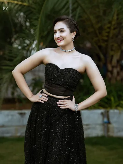 A modern and chic black two-piece ensemble with a strapless corset top and a sparkling sequined lehenga skirt.