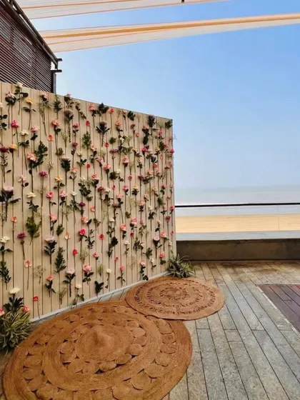 A side view of the delicate floral wall at a beachside venue, showing how it creates a stunning photo opportunity with the sea in the background.