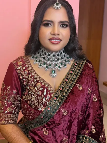 A smiling portrait of Ramya. The glossy lips and radiant skin complete this perfect reception look.