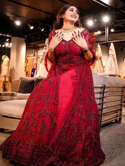 This candid-style shot captures the happiness and radiance of a bride-to-be. The vibrant red gown stands out, and the model's smile brings a beautiful, authentic energy to the photograph.
