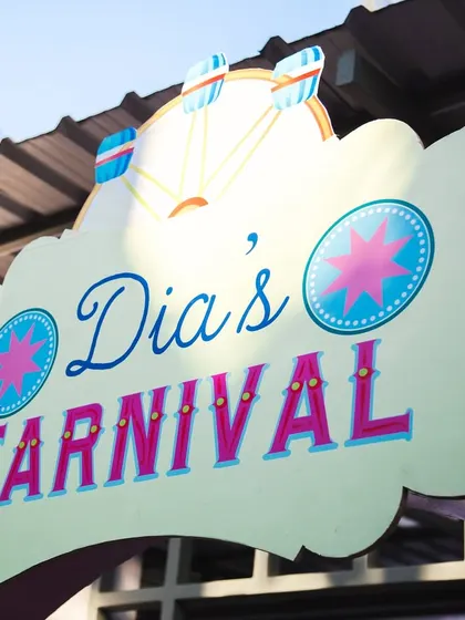 The custom-designed sign for "Dia's Carnival." The fun typography and bright colors perfectly capture the playful spirit of the event.