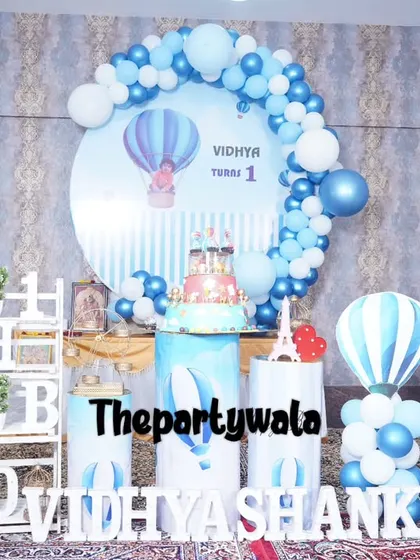 A sweet Hot Air Balloon theme for a first birthday, with a large backdrop and themed pedestals.