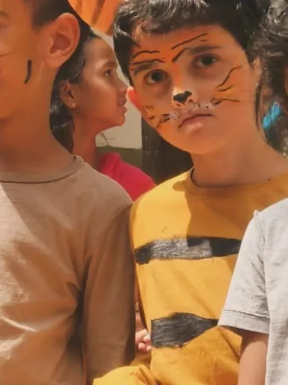 The children's faces are painted to transform them into the animals of the forest. This creative process is as much a part of the learning as the final performance itself.