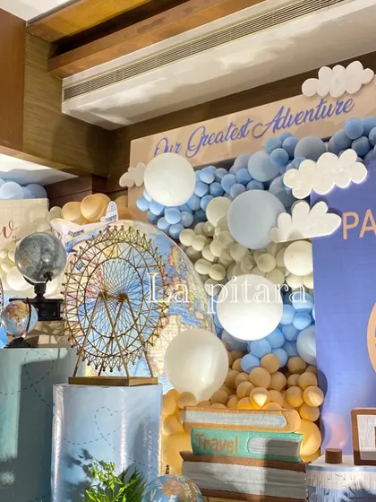 A detailed shot of the stage, highlighting the Ferris wheel prop against a world map and a cascade of blue and white balloons.