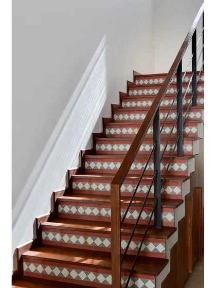The staircase in Nataraj House is a design feature, with traditional terracotta-hued cement tiles on the risers and warm timber-clad treads.
