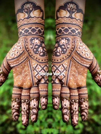 A symmetrical design featuring swans on the wrist and a central mandala, surrounded by lotus details on the fingers.