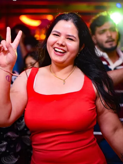 A joyful moment on the dance floor. This partygoer's smile is infectious, capturing the spirit of a great Bollywood night.