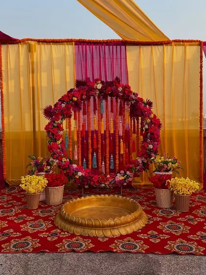 A closer look at the rooftop ceremony backdrop, featuring a circular frame decorated with flowers and tassels.