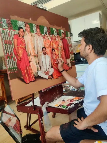 Here you can see the artist adding the final, detailed touches to a large family group portrait. Every person is painted with care to capture their unique likeness and personality.