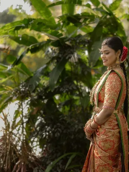 A bride in a lush, green garden. The soft, diffused light is perfect for capturing the delicate colors of her saree and her serene expression.
