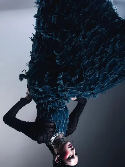 An inverted photograph of a model in a dramatic, textured blue dress. This simple act of flipping the image creates a surreal, gravity-defying effect that is both disorienting and visually captivating.