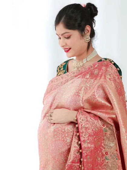 A quiet, contemplative pose in a traditional saree. This side profile beautifully highlights the baby bump and the elegant drape of the fabric.