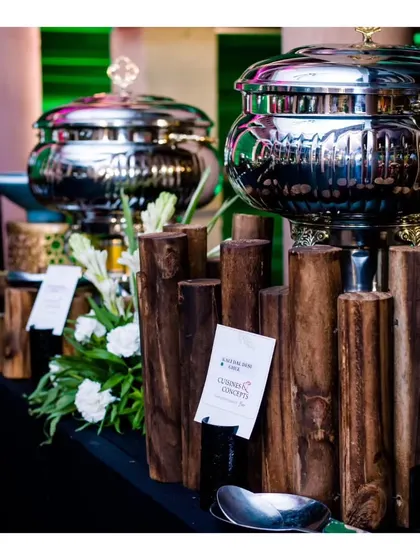 A modern and chic buffet station with sleek silver chafing dishes and a minimalist wooden log design, showcasing our versatile decor capabilities.