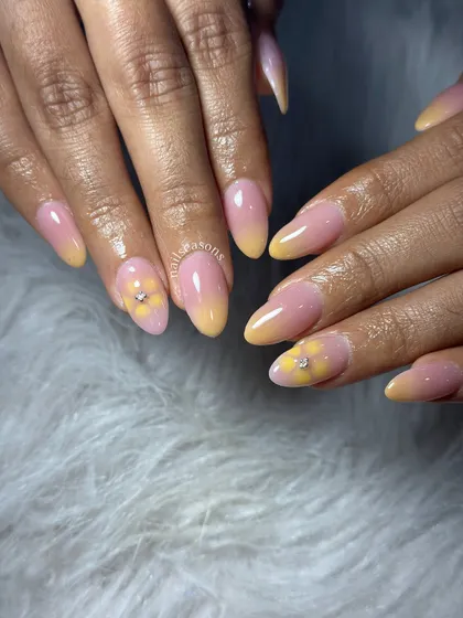 A soft and sunny design with a pink and yellow ombre base and a delicate, hand-painted flower accent.