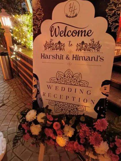 A personalized welcome sign for Harshit and Himani's wedding reception, featuring a cute caricature and elegant design.