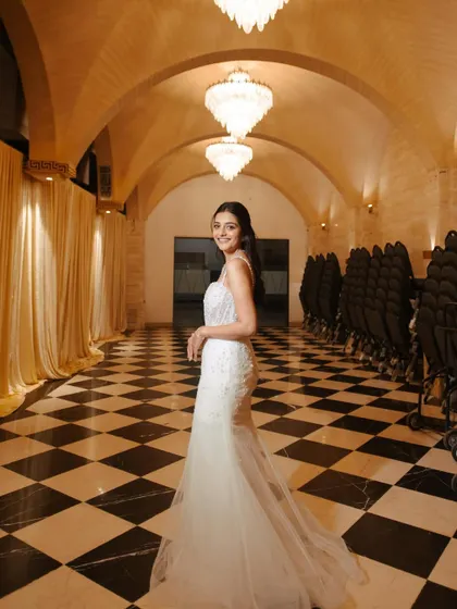 A full-length shot of the bride in a stunning hallway, her simple yet elegant hairstyle adding to the overall sophistication.
