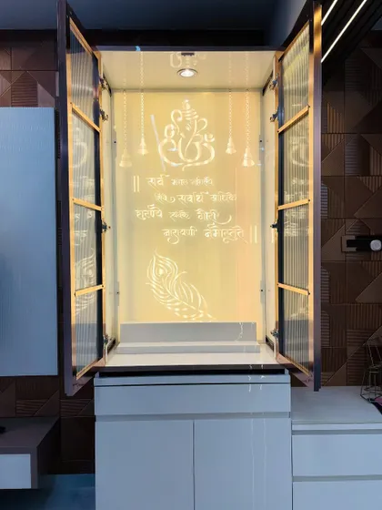 This is a custom-built pooja unit I designed, featuring fluted glass doors that conceal the sacred space when not in use. Opening the doors reveals a beautifully backlit panel with the Ganesh mantra, creating a serene and divine corner within the home.