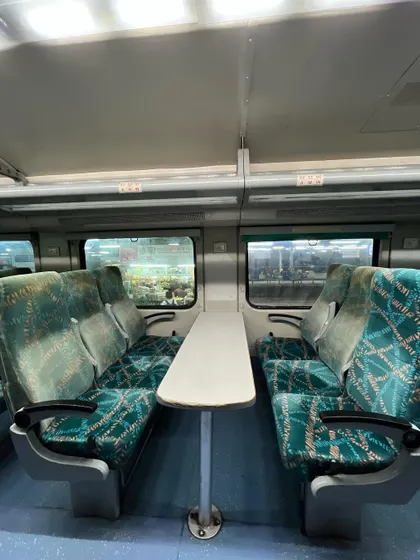 The face-to-face seating arrangement with a table in between, a feature of the double-decker train's chair car.