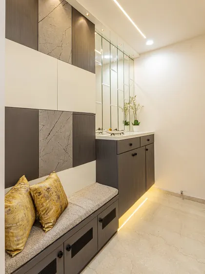 I designed this entryway with a built-in seating bench that doubles as shoe storage. The wall features a mix of textured panels, and the vertical mirrors make the space feel larger.