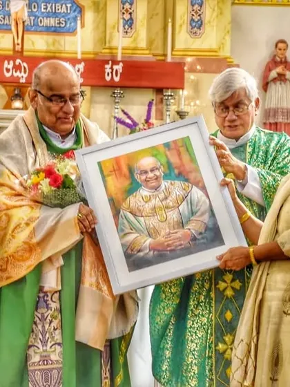 This photo shows my portrait of Msgr. Leslie Shenoy being presented at Bendur Church, a group moment celebrating art and community.