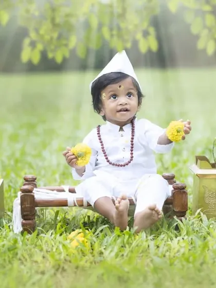 This little Varkari is holding flowers as an offering. The details in this themed cultural photoshoot, from the props to the soft lighting, create a truly dreamy and divine image.
