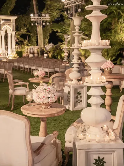 The guest seating area for the Birla House wedding, featuring elegant lounge furniture, floral centerpieces, and sculptural candle stands.