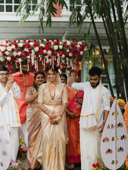 The bride's grand entrance, a moment filled with tradition and emotion. Her makeup is set to be flawless under the flower canopy, ensuring she looks perfect from every angle.