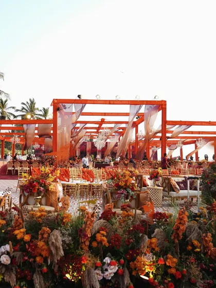 The decor for this Goa wedding was a celebration of sunset colors, with warm orange and red florals creating a vibrant and romantic atmosphere.