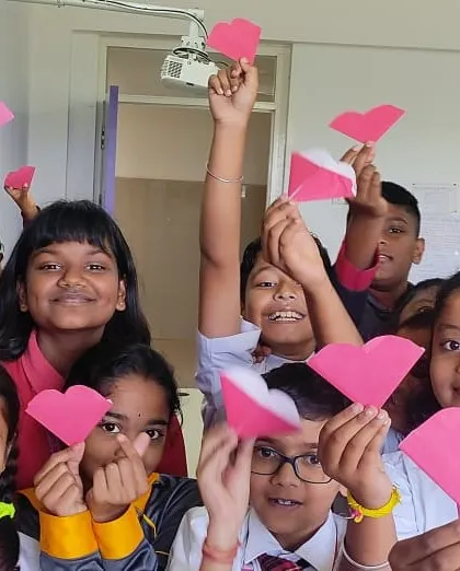 Students celebrate with heart-shaped paper crafts, spreading love and positivity through their art.