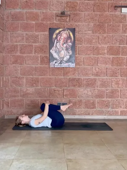 The starting position for our Supta Pawanmuktasana warm-up. Hugging the knees to the chest helps to gently press the lower back into the mat.