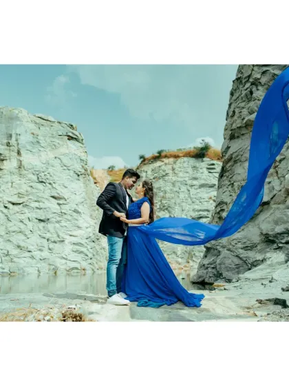 A striking contrast of a brilliant blue gown against the rugged texture of a rock quarry. The flowing fabric adds a soft, dynamic element to this dramatic destination pre-wedding photo.