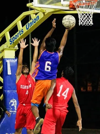 A contested layup during a night game. Playing under the lights requires a different level of focus and conditioning.