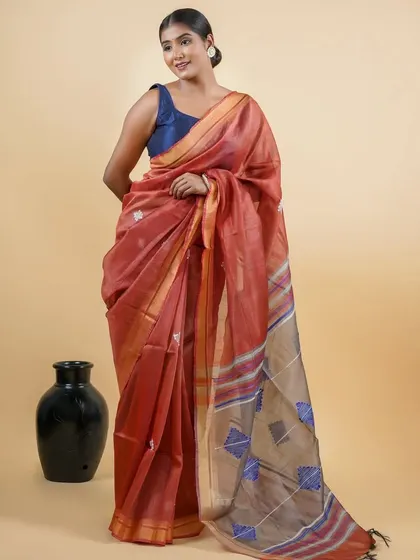 A model wearing a rust-colored Maheshwari silk cotton saree. The lightweight fabric and rich color make it a perfect choice for an elegant yet comfortable look.