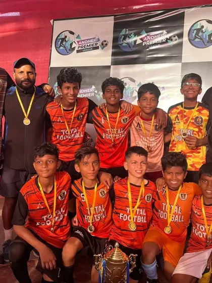 The U13 champions posing with their trophy and coaches at the Andheri Premier League.