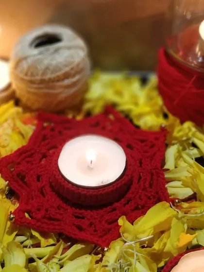 Our red star-shaped diya holder nestled in a bed of marigold petals. This image captures the essence of a traditional Diwali, elevated with a touch of handmade crochet art.