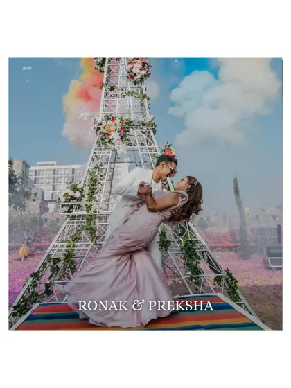 A romantic dip in front of a mini Eiffel Tower structure. This shot is a perfect blend of romance, fun, and the creative decor of a wedding carnival.