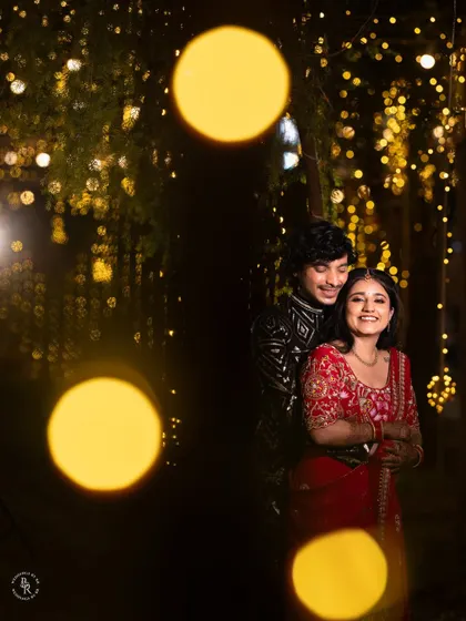 A romantic portrait of the couple against a backdrop of bokeh lights, capturing the magic of their reception night.