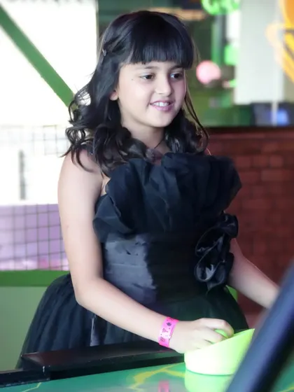 A candid shot of a young girl enjoying the activities at a birthday party.
