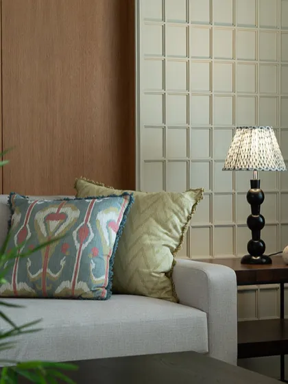A detail shot focusing on the textures and patterns of the throw pillows on the sofa. The ikat print and woven fabrics add a layer of handcrafted charm.