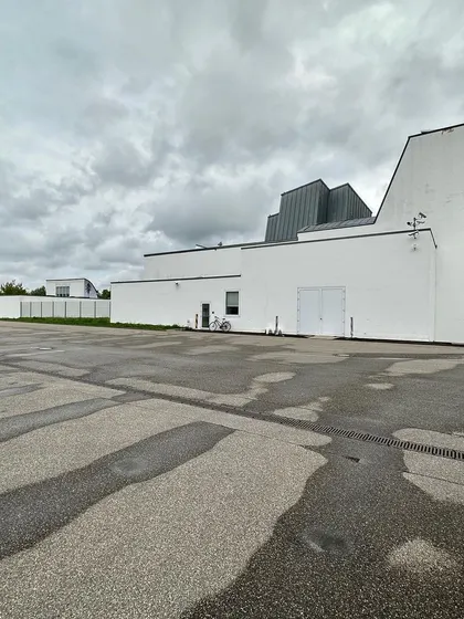 A wide view of the Vitra Design Museum by Frank Gehry. The building is an assembly of distinct geometric volumes, unified by their white plaster finish and zinc roofs.