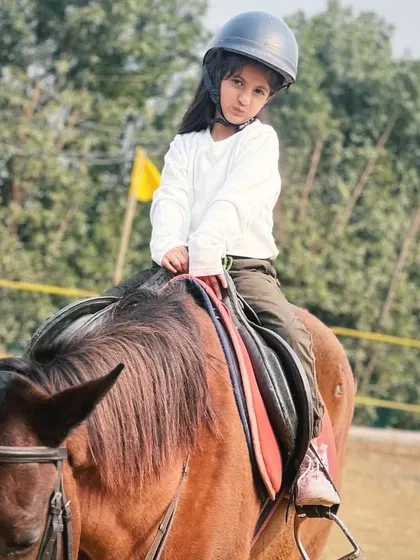 A young equestrian in her helmet, focused and ready to ride. We instill the importance of safety gear from the very first lesson.