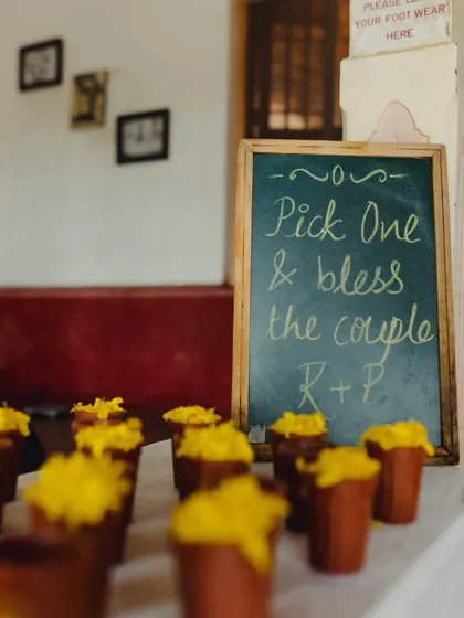 A charming chalkboard sign inviting guests to bless the couple with flower petals.