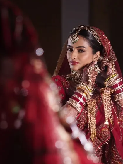 A bride's quiet moment of reflection before the ceremony. This image captures the elegance of a traditional red bridal look, with makeup designed to be timeless and photograph beautifully from every angle.