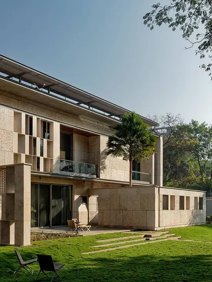 The rear facade of the Aqua Grid house, showing how every room opens onto a veranda or deck. The building is designed to exist under the canopy of the site's large trees.