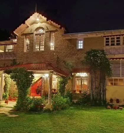 The Chevron Rosemount Hotel in Ranikhet illuminated at night, highlighting the architectural features and warm, inviting ambiance.