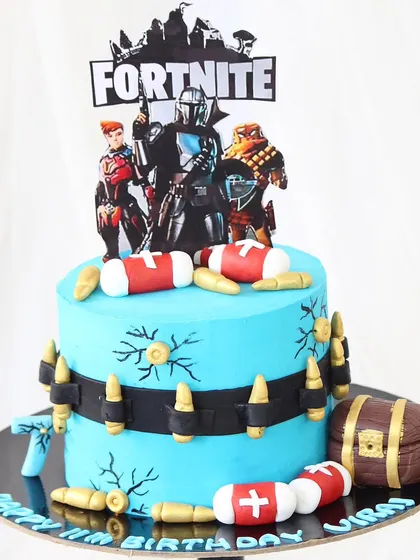 Get ready for a victory royale with this Fortnite-themed cake. The design includes an edible treasure chest, medkits, and a bullet belt, all crafted from fondant, perfect for any gamer's birthday.