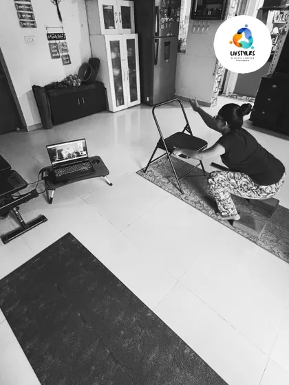 This black and white shot captures a client using a chair for a modified squat during a virtual session. It highlights my focus on using accessible props to ensure proper form, even when training online.