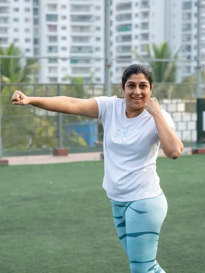 A member smiles while practicing her boxing stance during the 'Energize at Dawn' bootcamp.