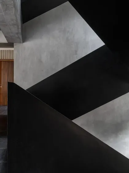The abstract beauty of the Brick House staircase, where light catches the edges of the black plaster forms, creating a dance of highlights and shadows.