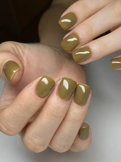 A trendy olive green manicure on short, square nails. This earthy shade is both stylish and understated.